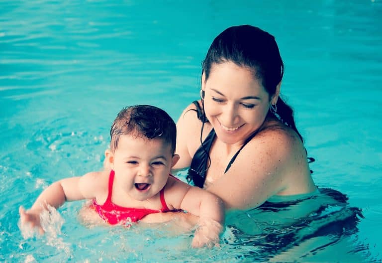 Mamá y bebé juegan en la piscina