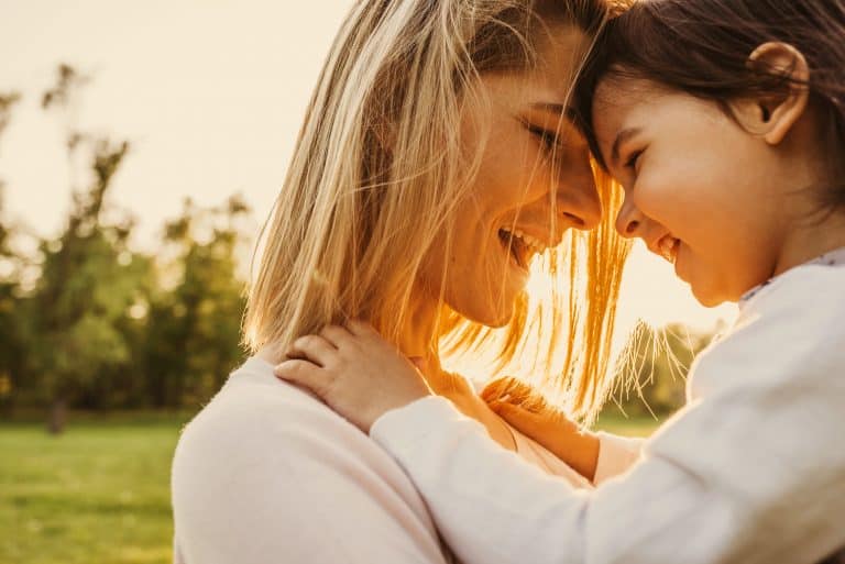 Madre e hija unen sus cabezas cómplices y sonriendo