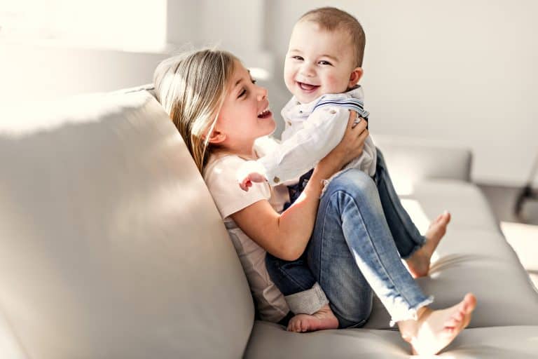 Little Sister With Her Baby Brother. Toddler Kid Family With Children At Home.