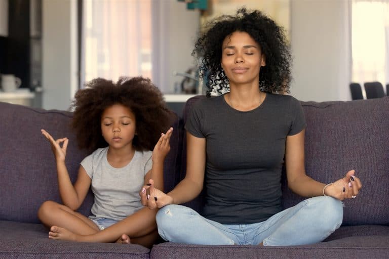 Mindful African Mom With Funny Kid Daughter Doing Yoga Together