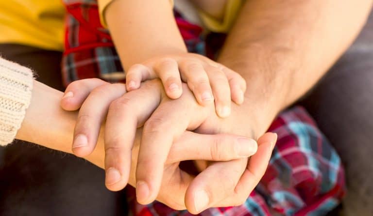 Child Hand Closeup Into Parents. Hands Of Father, Mother, Keep Hand Little Baby. Parents Hold The Ba