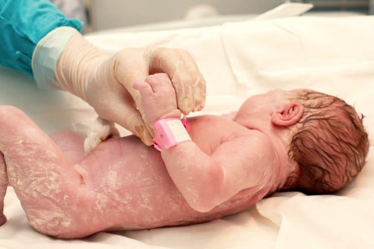 Primer baño de bebé recién nacido. La madre lava al bebé con una