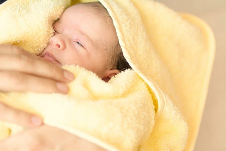Newborn After Taking A Bath. Little Baby Wrapped In Towel