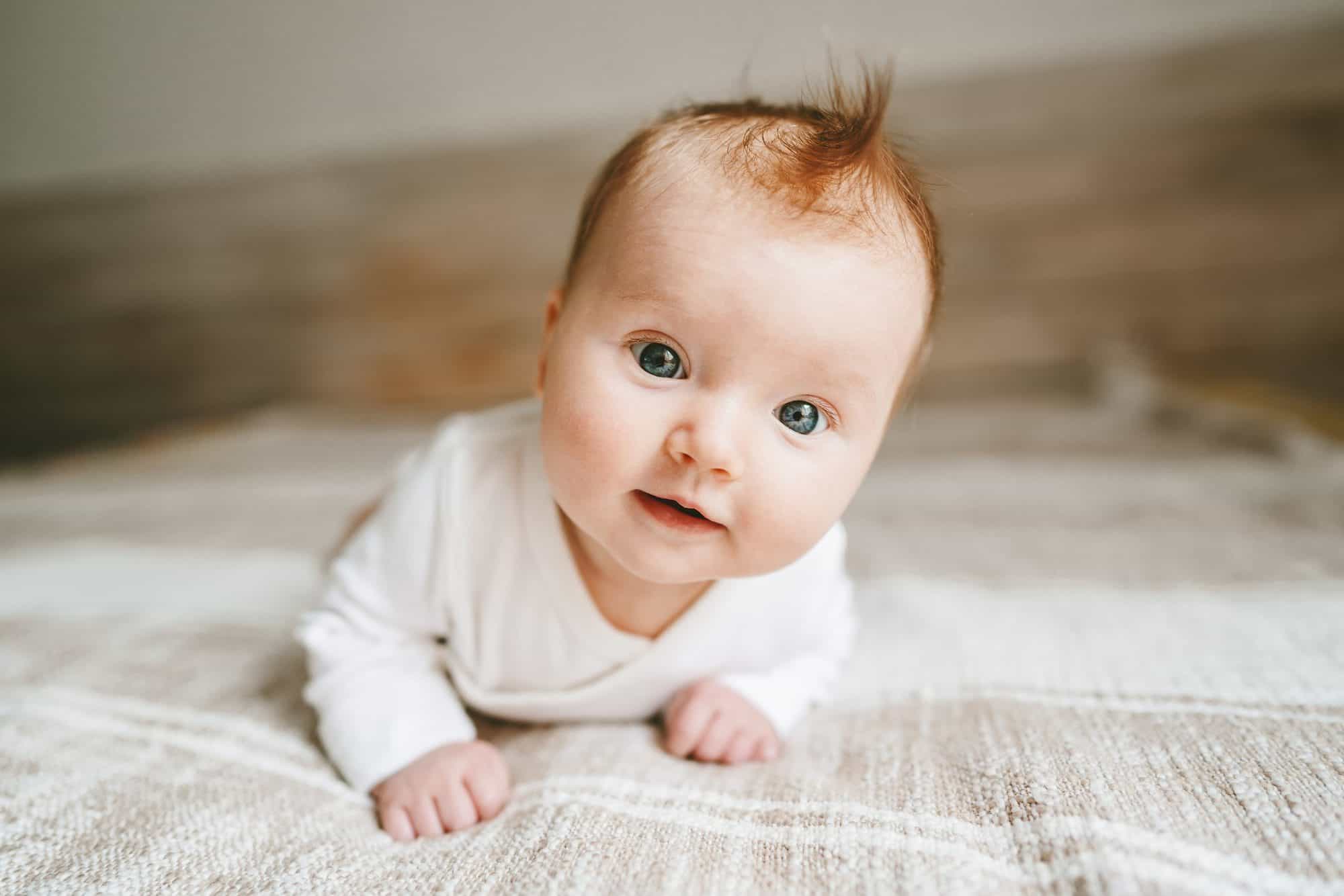 Un bebé con pelo rizado y camiseta blanca generado por ia